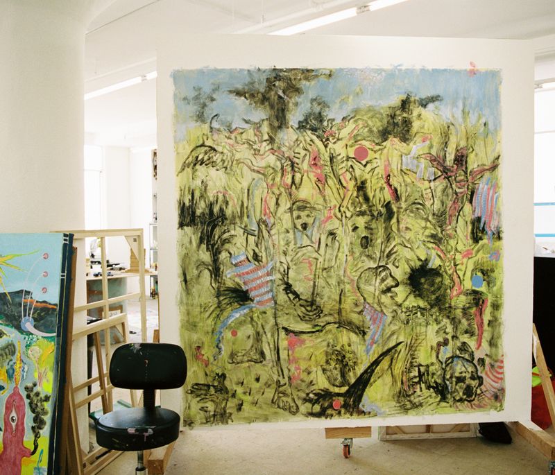 artist's studio with a black office chair placed in front of a large square surrealist painting in mostly yellow paint with black details and lines