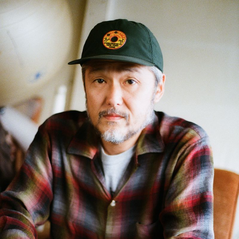Close-up of artist Tomoo Gokita wearing a shirt and cap