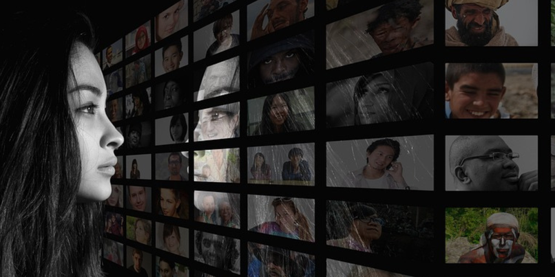 A woman in profile gazes at a wall filled with diverse portraits of people from various backgrounds, depicted in a digital and artistic style.