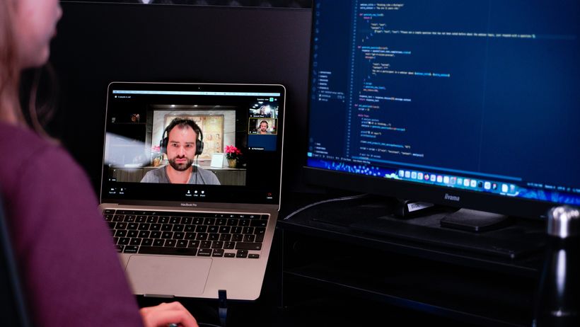 Laptop with meeting and screen with code