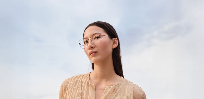 Frau trägt Titan Minimal Art mit roter Farbrille