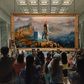 People taking pictures in an art gallery but the image is Laufey from God of War