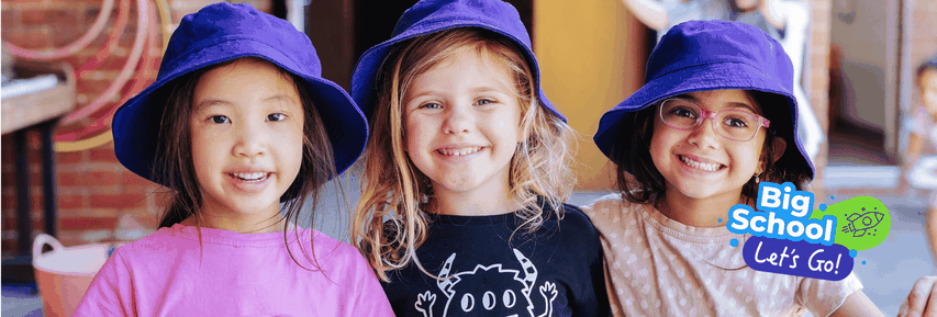 Three smiling children wearing purple hats stand together, with a "Big School Let's Go!" graphic on the right.