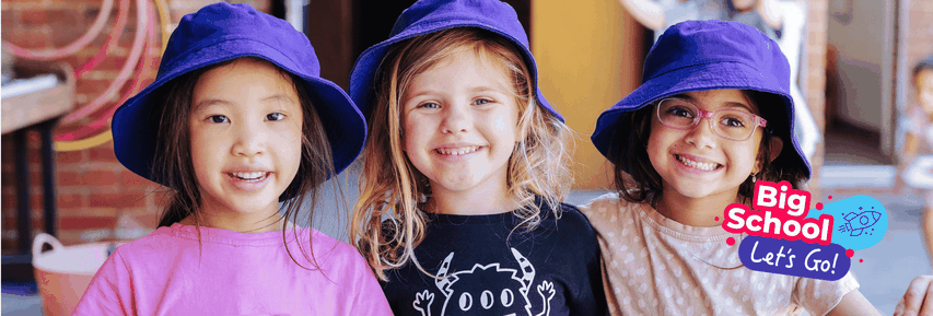 Three smiling children wearing purple hats stand close together, with graphics that say "Big School Let's Go!" on the right.