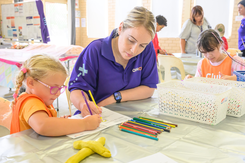 Educator with child creating Christian crosses.
