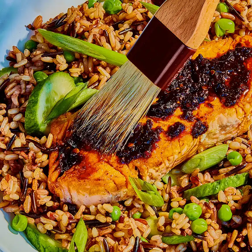 brushing Zhong Sauce on cooked salmon with wild rice