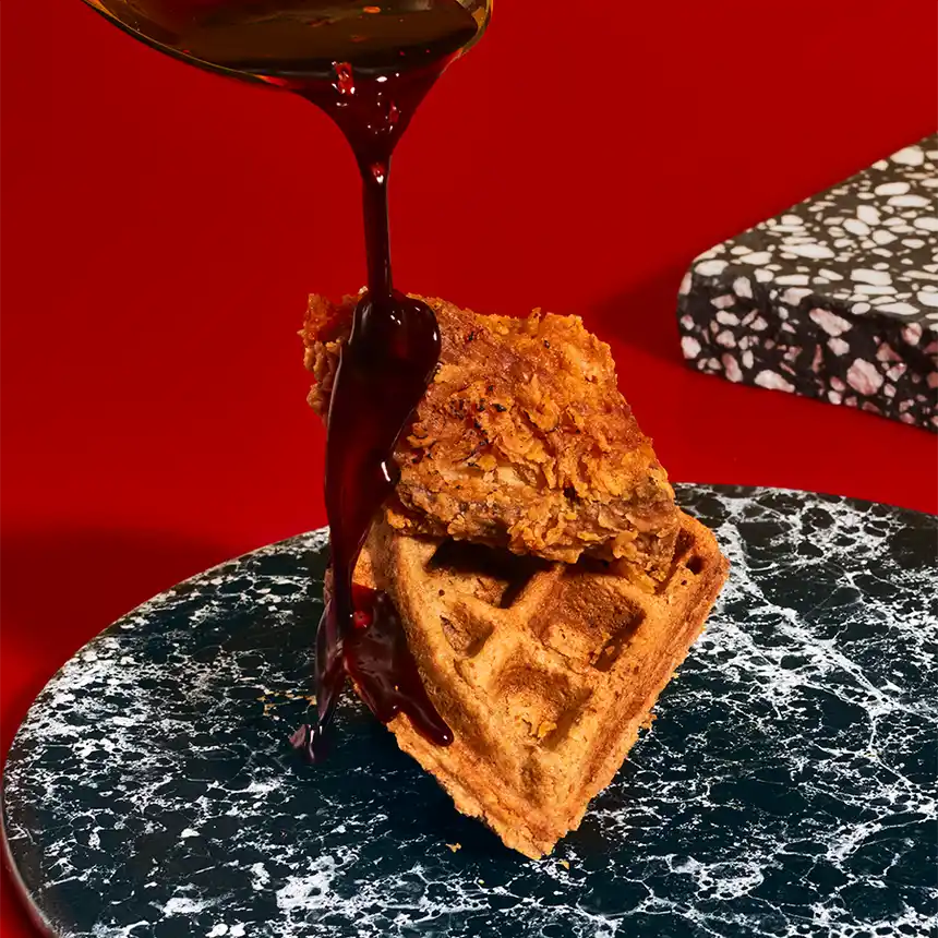 Spicy Sovereign Syrup pouring on chicken and waffle