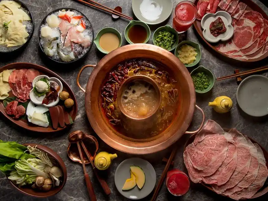 Overhead image of hot pot dinner with various dishes of food