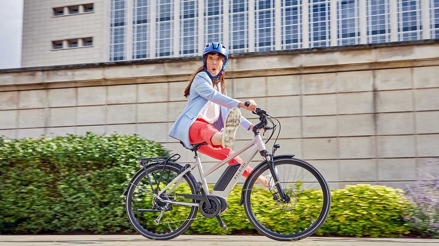 A Lady riding a Raleigh Motus ebike through the city 