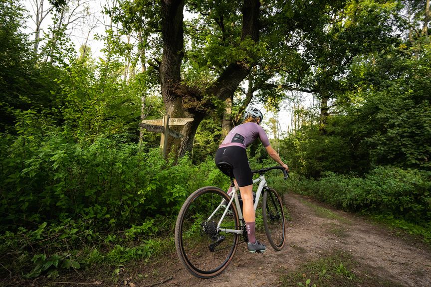 Lady riding a gravel bike in the woods