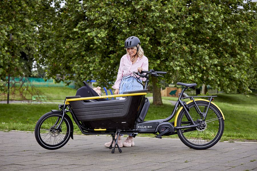 Woman riding Raleigh Stride 2 electric cargo bike