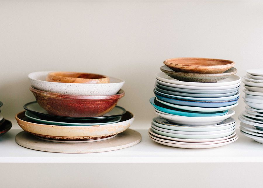 Unhappy with home care- Cropped photo showing stacks of different coloured plates and bowls on a white shelf
