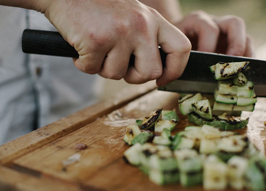 Home care services- photo of hands chopping zucchini on a women chopping board
