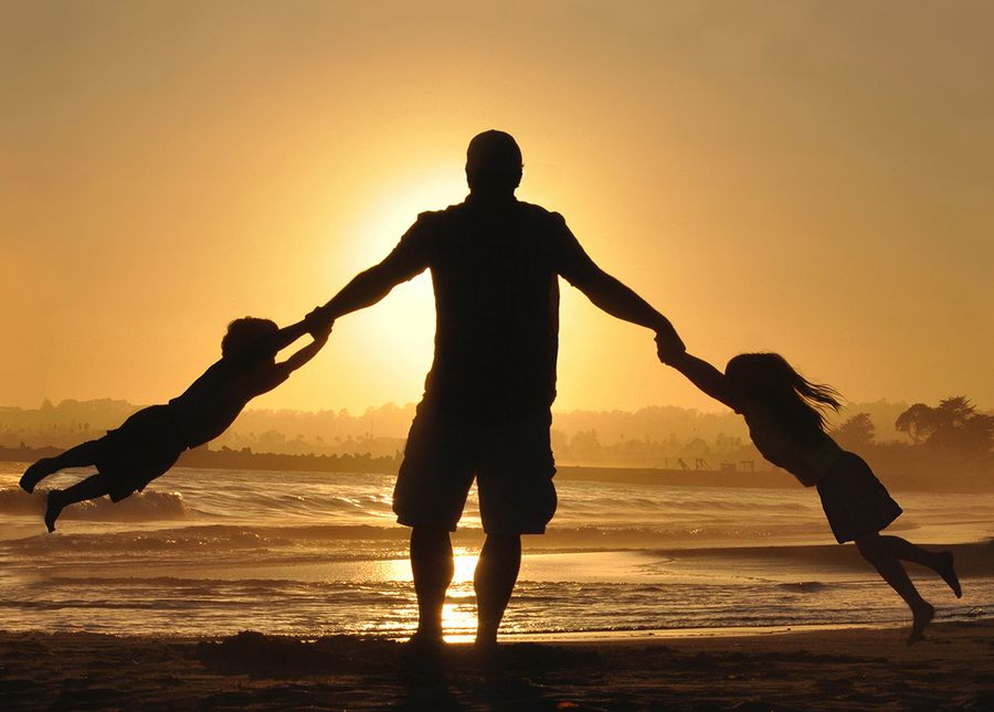 DailyCare journey- Photo of a silhouette of a man swinging his two children at sunset at the beach