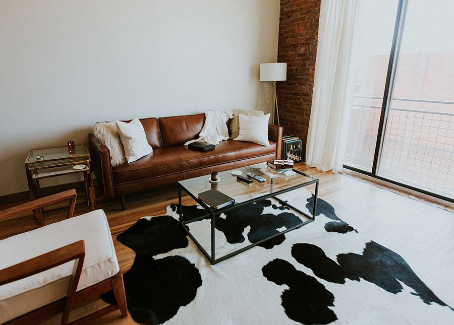 Home care packaged- photo of someone's lounge room with brown leather lounge, sliding glass doors and a black and white cow hide rug