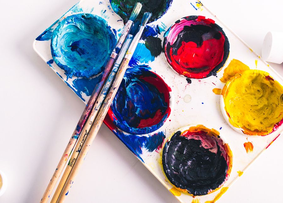 Aged care activities- Photo of a white plastic paint palette with blue, red and yellow paints and three paint brushes