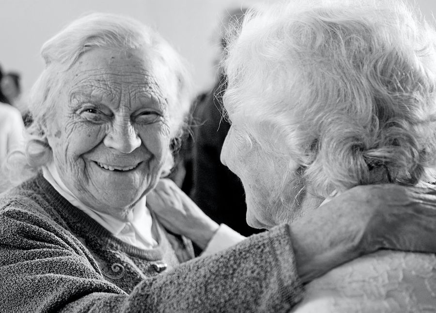 Dementia and home care- Two older ladies dancing and smiling