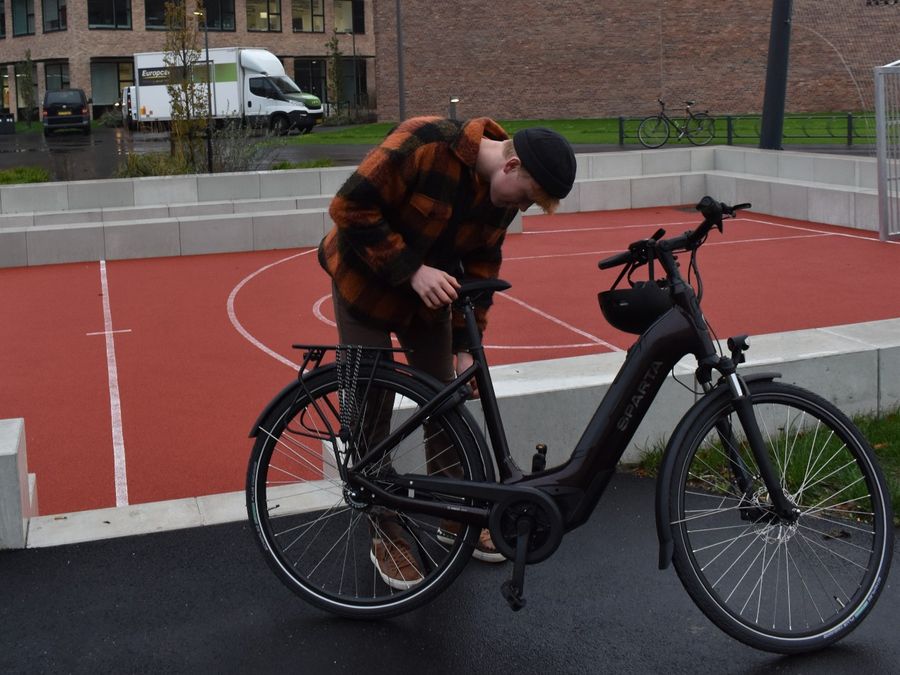 d-BURST ENERGY METB Sparta elcykel i sort bliver låst op af en dreng foran basketboldbane 