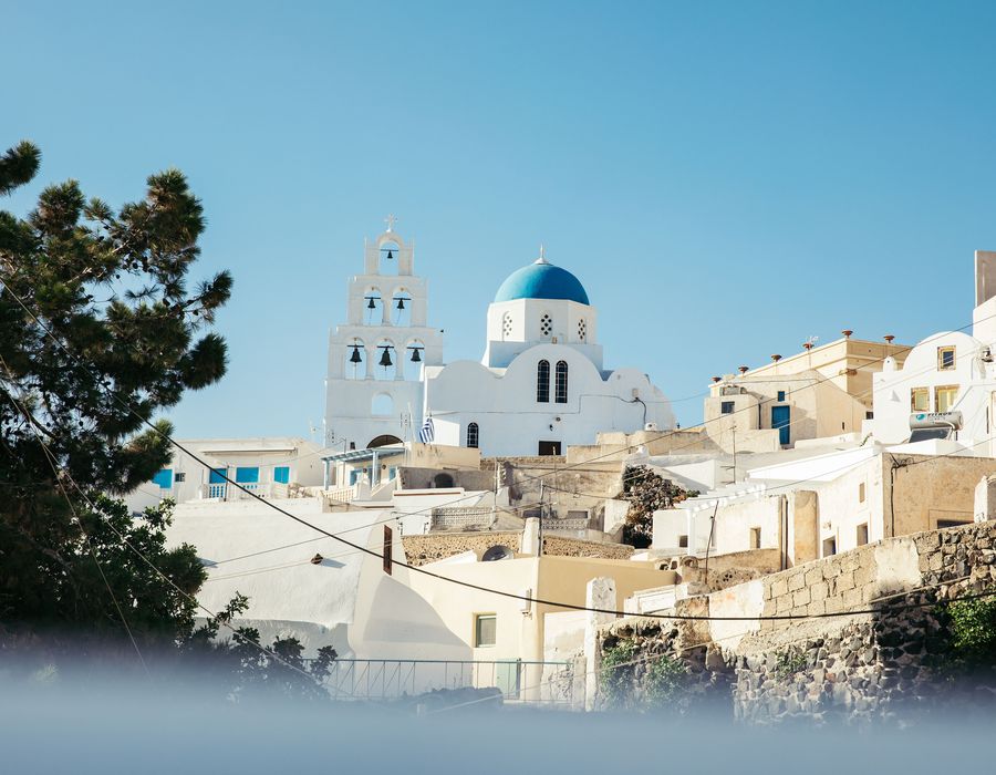 blue domed white building in greece with bells