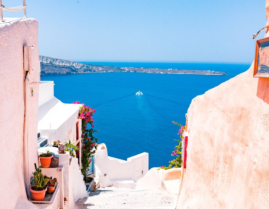 cream colored stairs leading down to the blue ocean in greece
