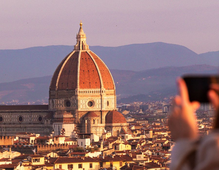 woman taking a photo of the duomo in florence, italy