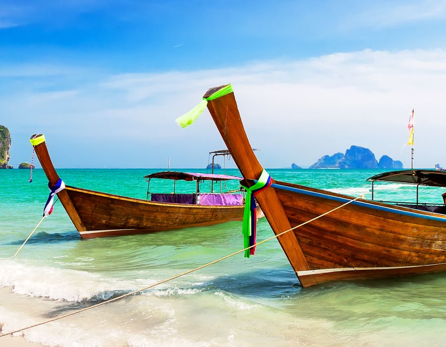 wooden boats docked on the beach off of the phi phi island