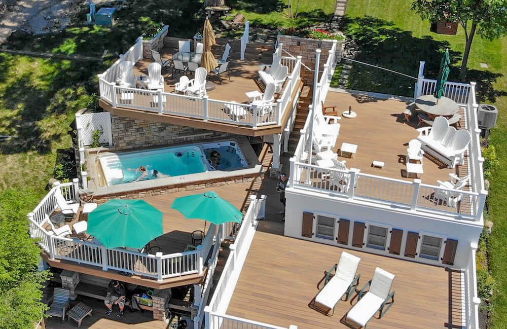 a drone shot of a house with multiple decks and an Endless Pools swim spa