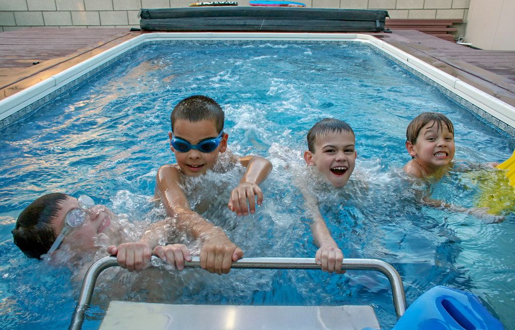 A picture of four kids struggling to stay ahead of each other as they swim against the current of their pool.