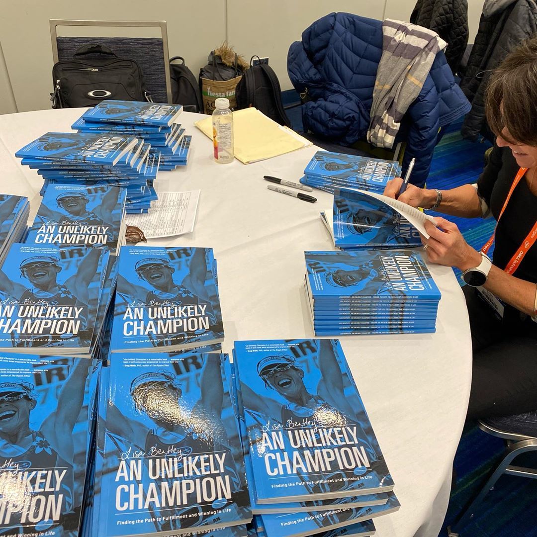 picture of author Lisa Bentley signing her book, An Unlikely Champion