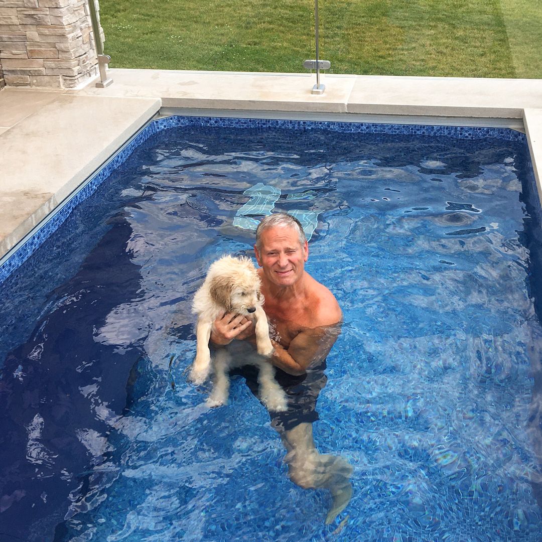 picture of man and dog in their backyard plunge pool
