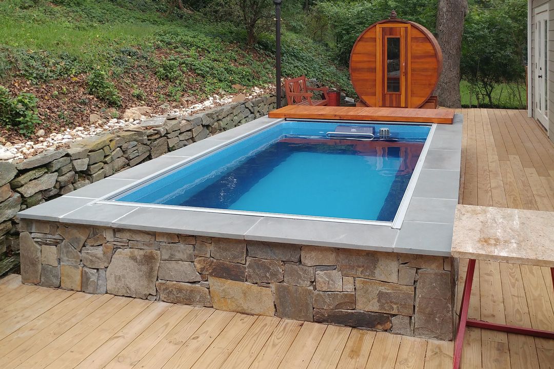 A picture of a partially in-ground, outdoor Original model installed in a wooden deck with stone skirting.