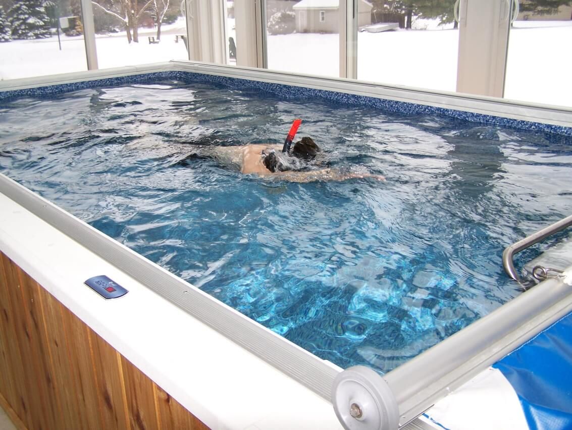 picture of swimming in an indoor Original Endless Pool during a winter snow