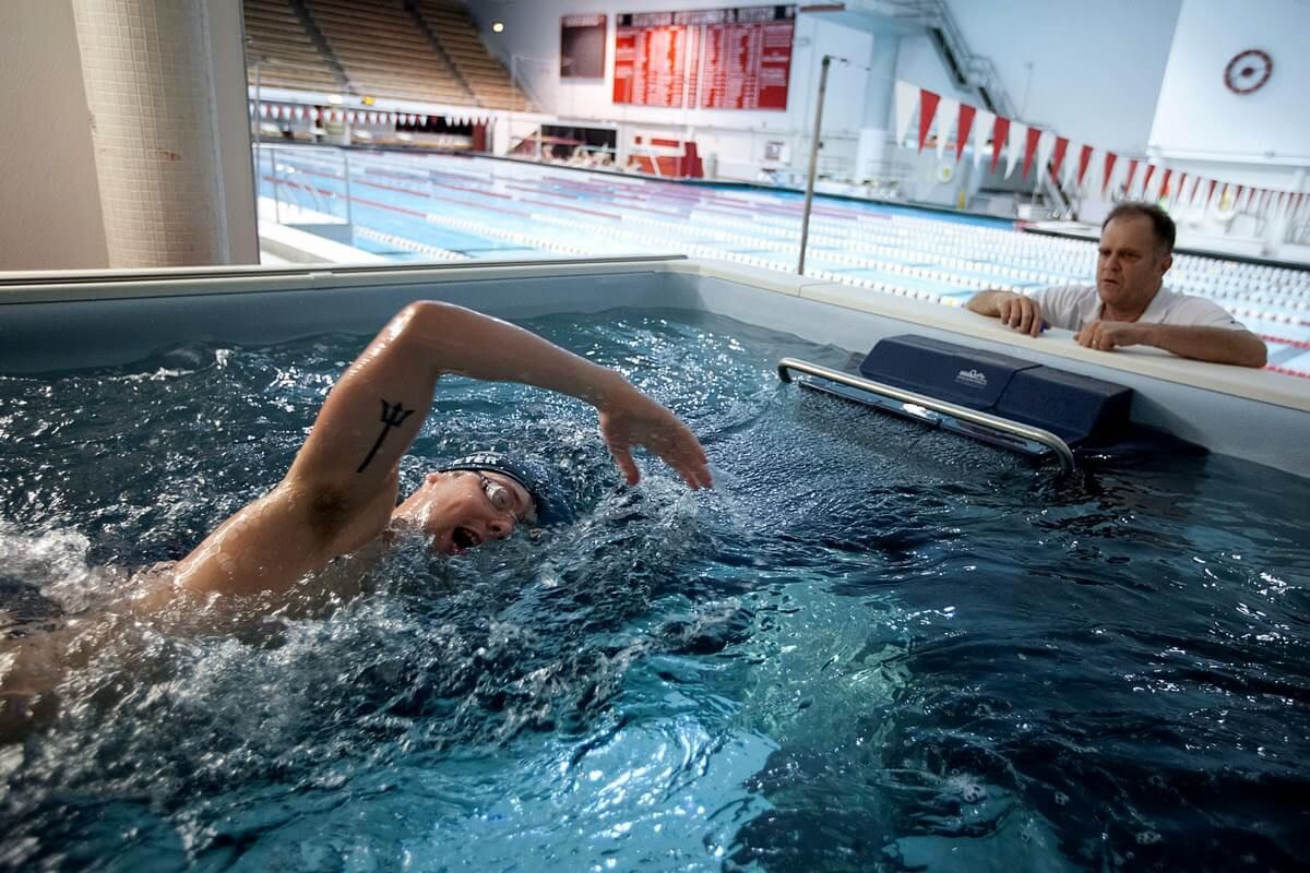 Swim coach Tim Murphy training Alex Meyer in the Elite Endless Pool at Harvard