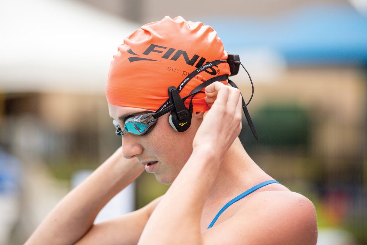 a swimmer adjusts the FINIS Swim Coach Communicator