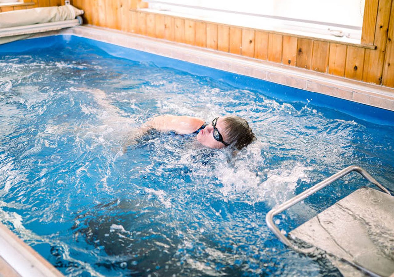 picture of Dr. Terry Walhs swimming as aquatic therapy in her Endless Pools home therapy pool