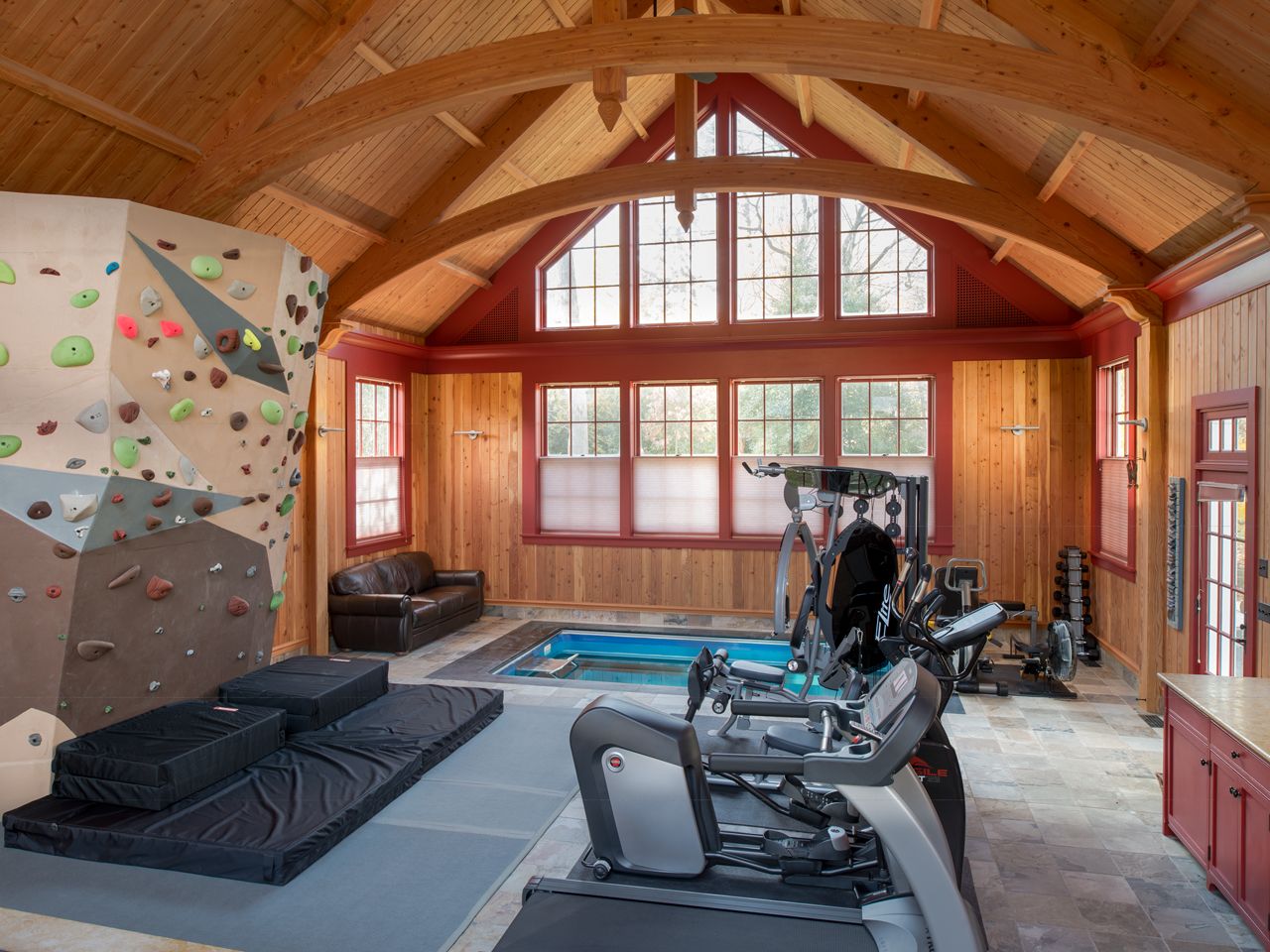 man cave with an Endless Pools swimming machine and other fitness equipment