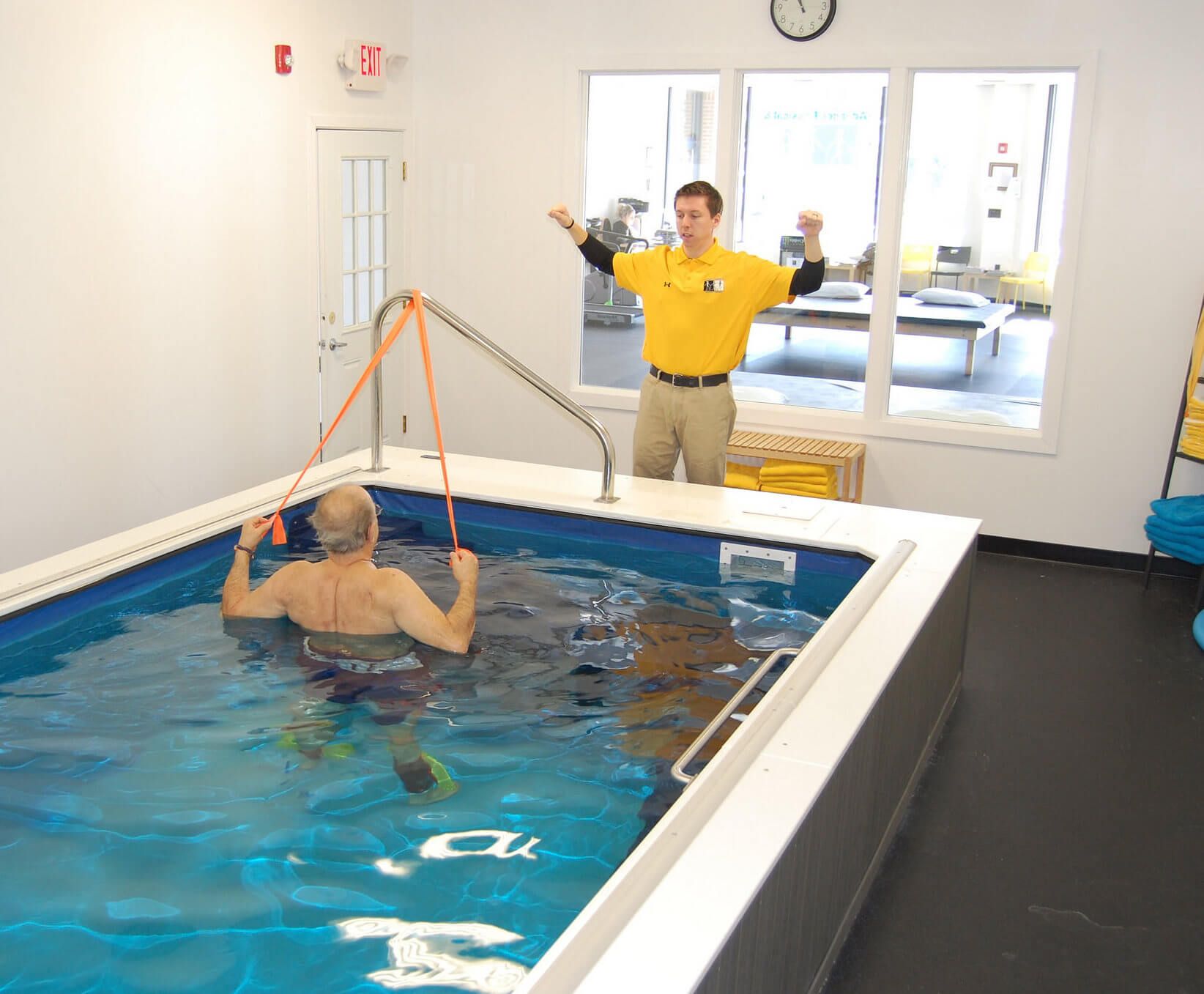 a physical trainer uses the Endless Pools WaterWell for aquatic therapy