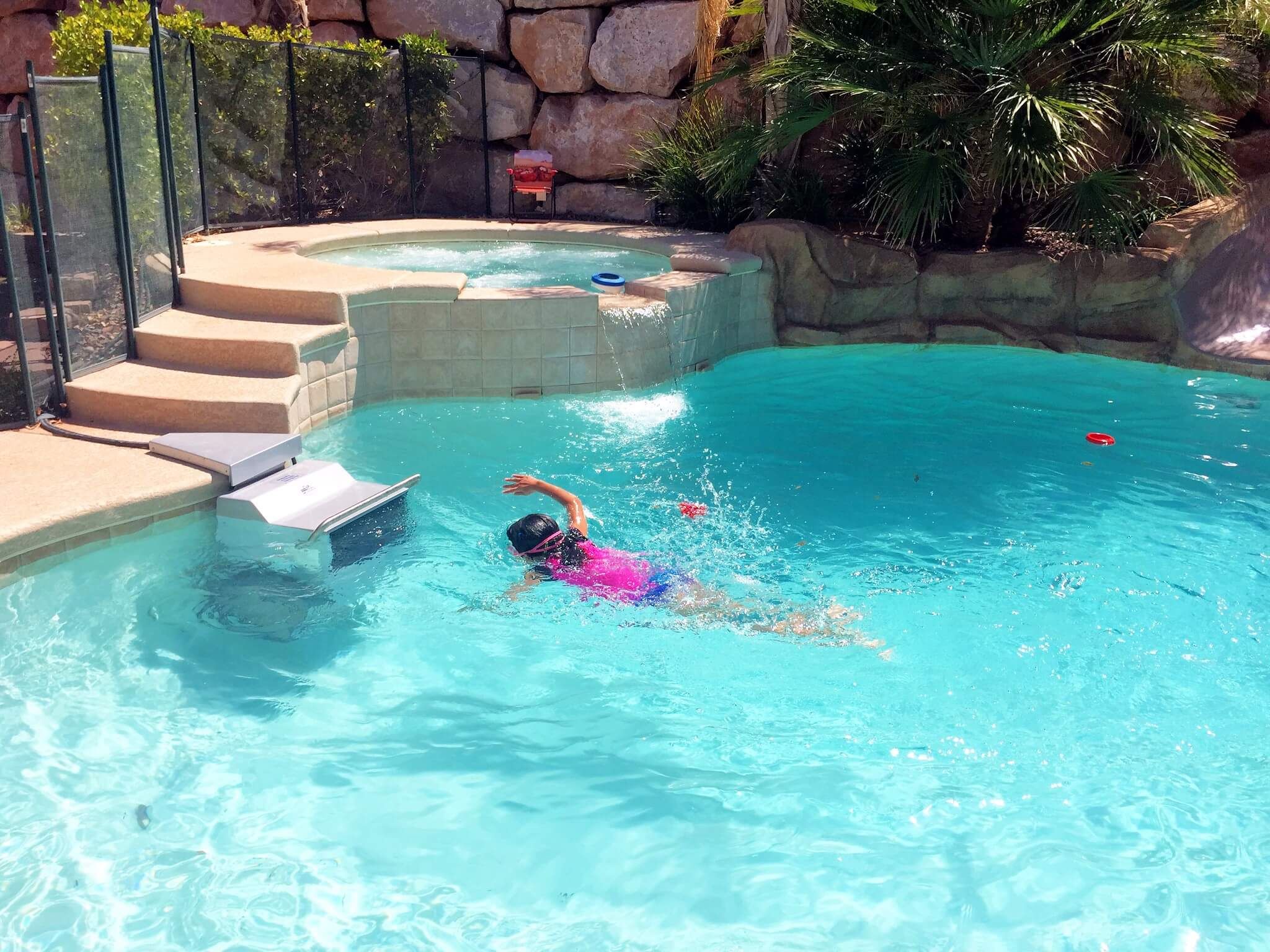 picture of a young swimmer uses the Endless Pools Fastlane in a backyard pool