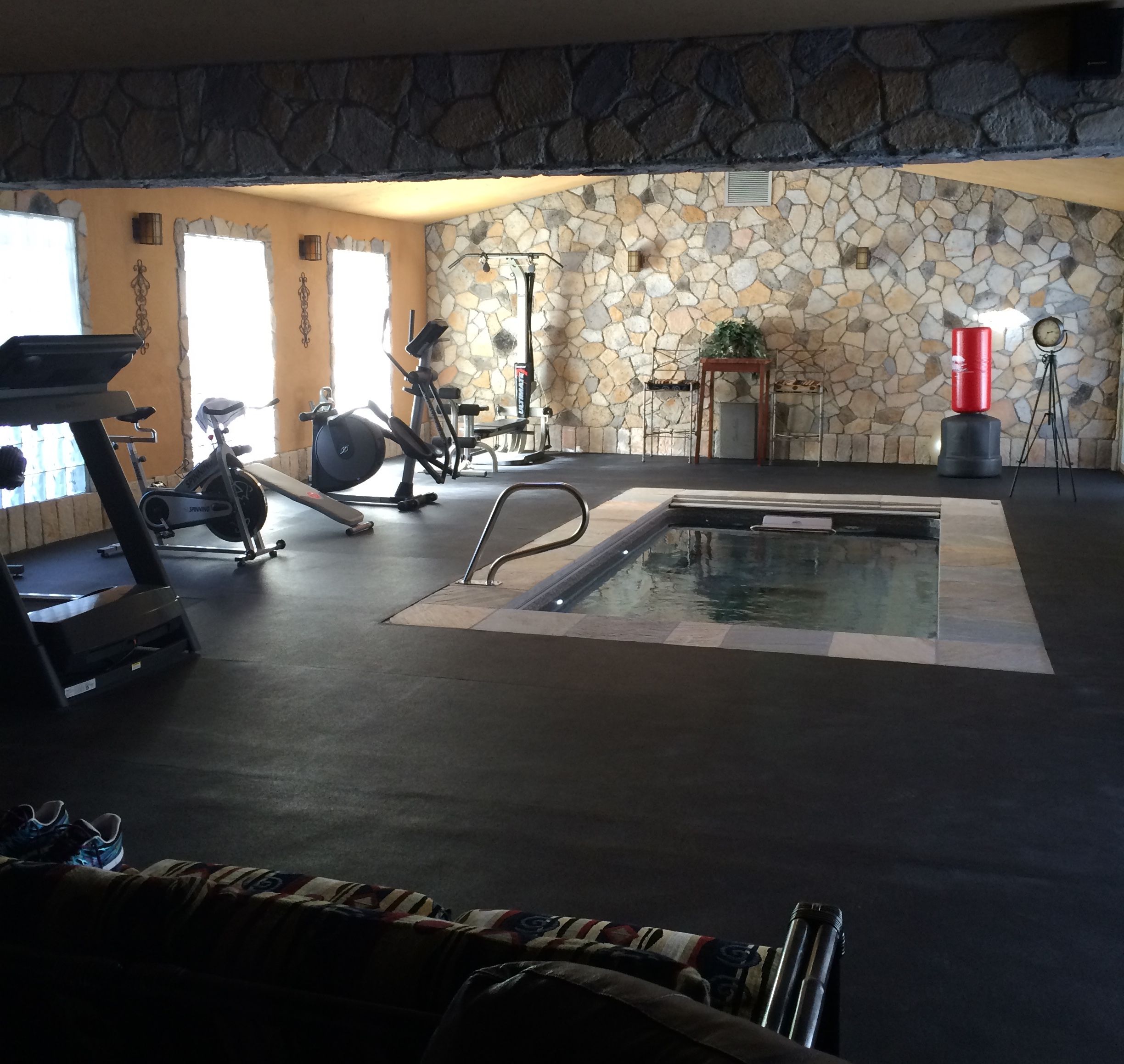 an indoor, fully inground Endless Pools swimming machine in a home gym