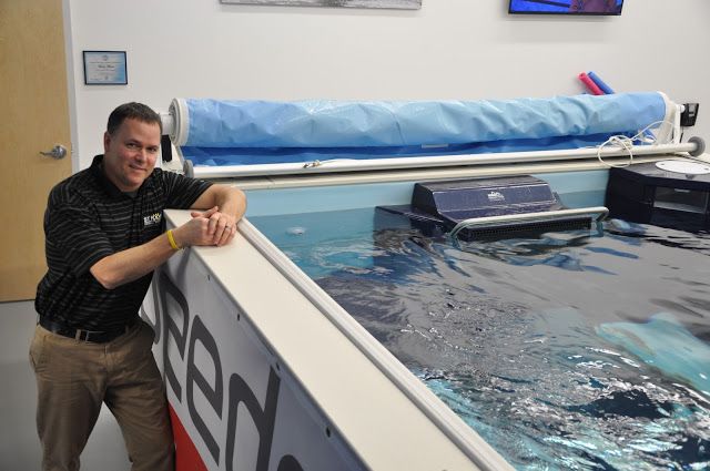 Swim Coach Dean Hutchinson in front of the Endless Pools swimming machine at Strive Physical Therapy