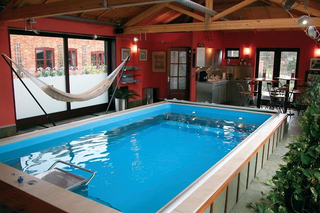 an indoor, partially in-ground Endless Pools swimming machine with a nearby hammock