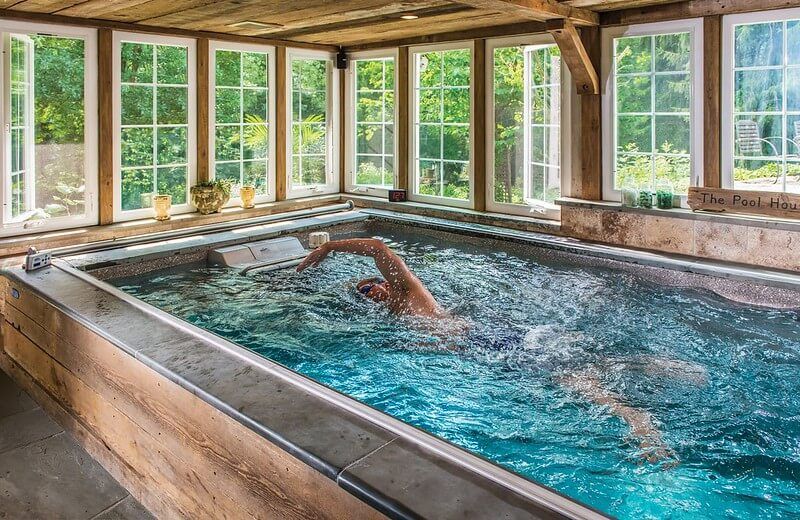picture of a swimmer using an Endless Pools Performance model in a sunroom
