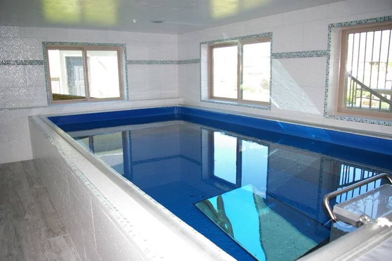 The compact Endless Pools&reg; installation used for year-round therapy in a sunroom