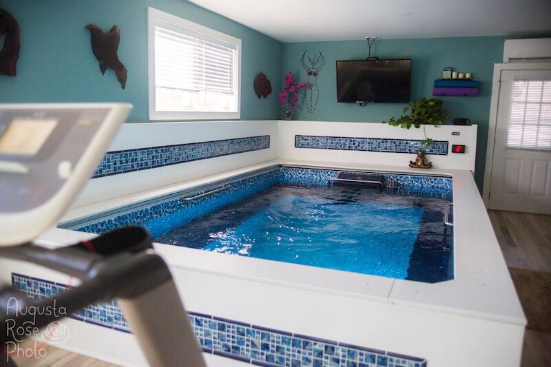 A picture of an above-ground garage pool with a TV set up above it.