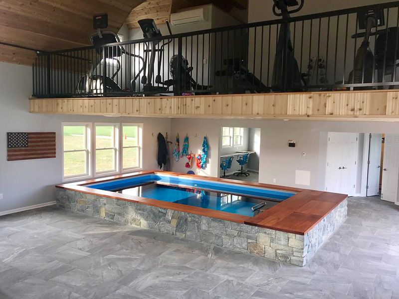 picture of two-level home gym with partially in-ground Endless Pools swimming pool
