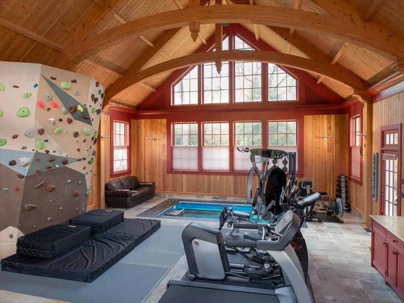 picture of indoor home gym with fully in-ground Endless Pools swimming pool and climbing wall