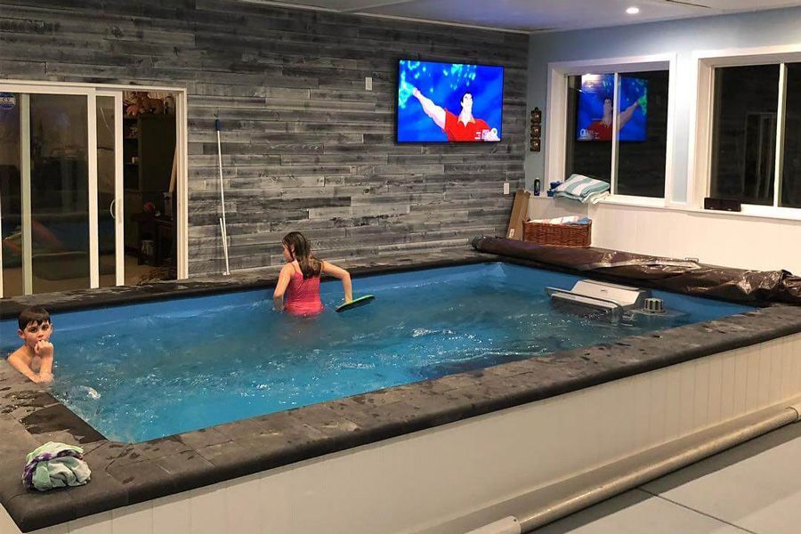 picture of Chris' son and daughter in his home addition with an Endless Pools partially in-ground pool