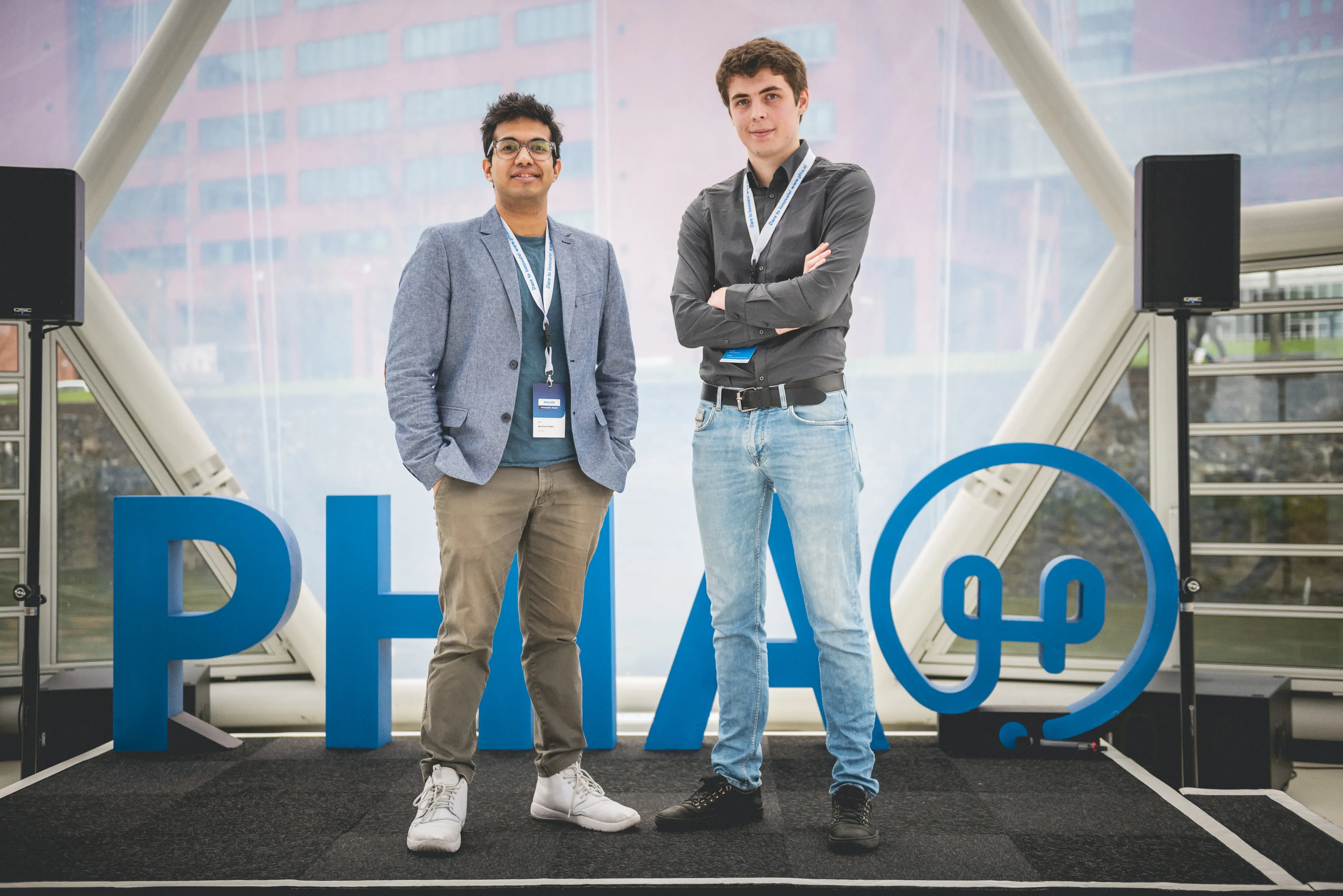 Freek and Ayush on stage with a PHIA logo behind them
