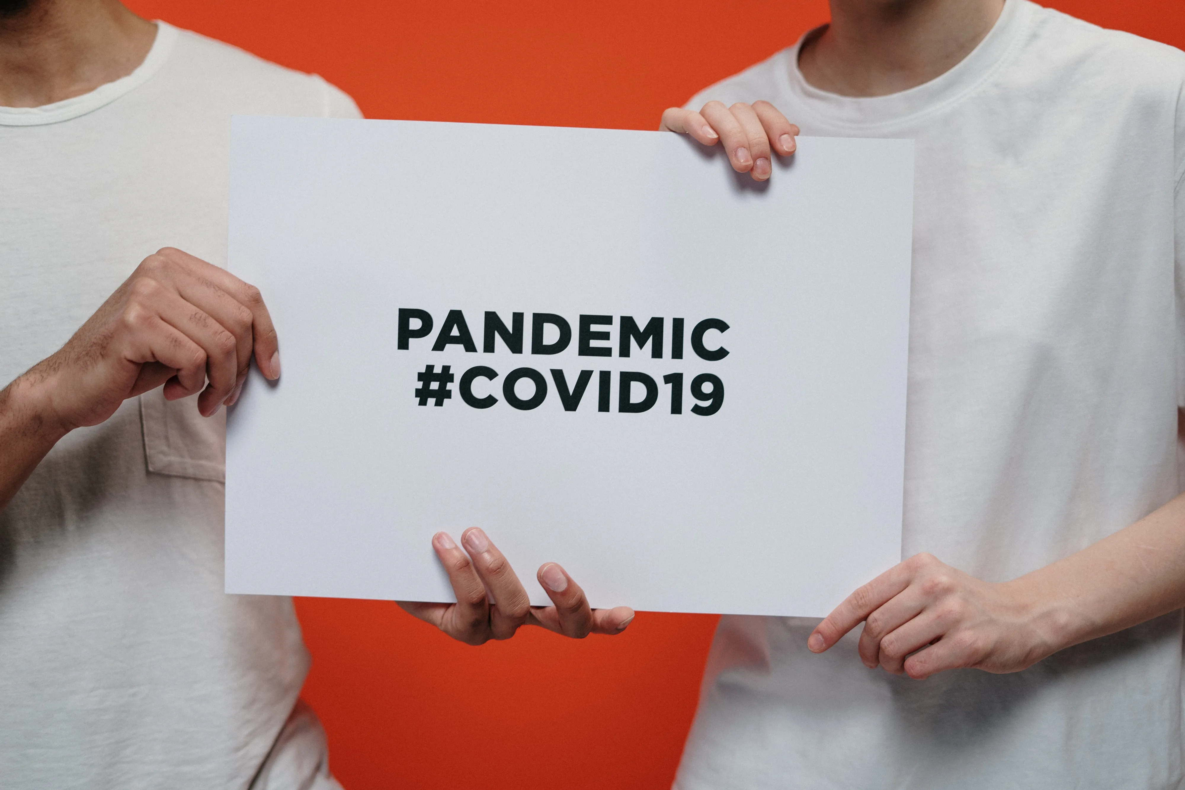 Two persons holding pandemic sign