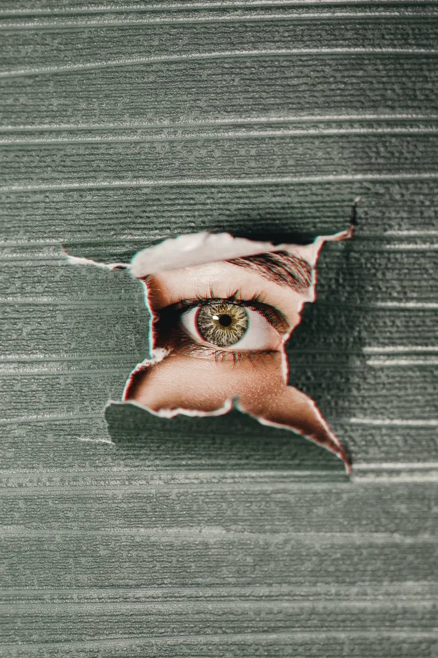 An eye looking through a big hole in the wallpaper